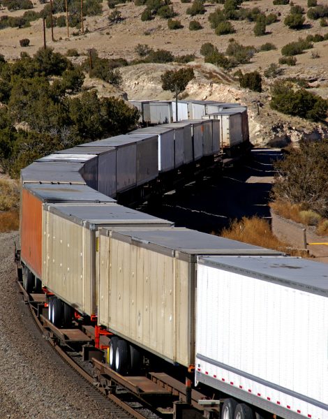 A moving train carries semi-trailers in a piggyback service. Photographed in New Mexico, USA.